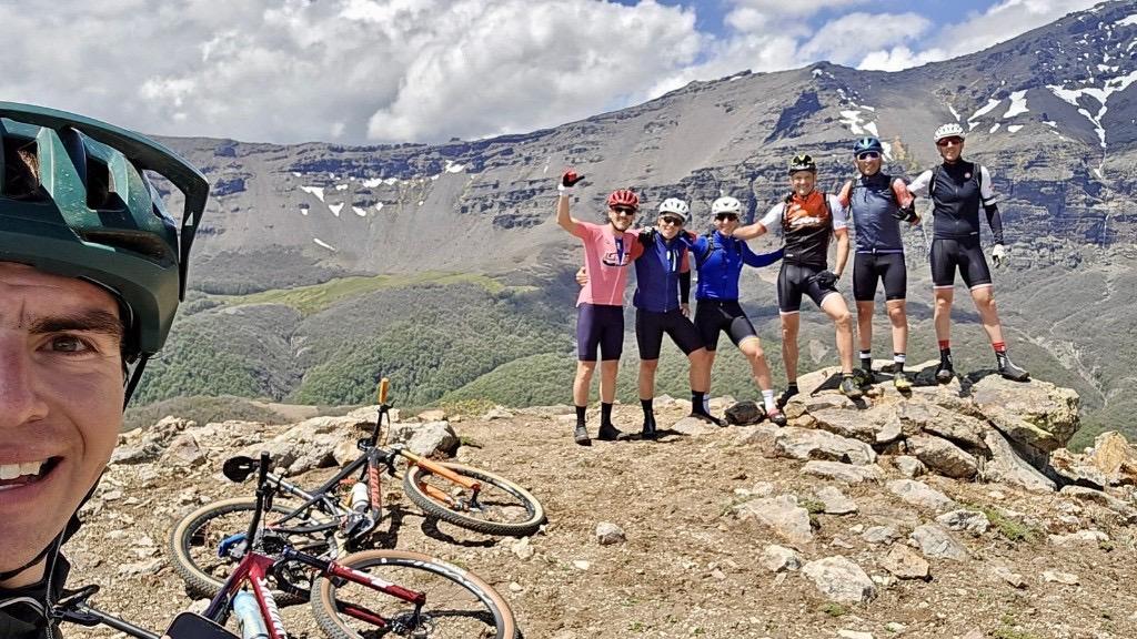 Grupo de ciclistas en la cumbre con vista a la Patagonia